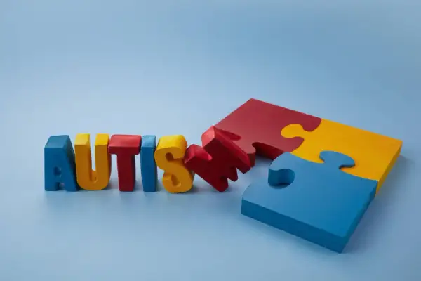 Kolorowe litery układają słowo "AUTISM", obok fragmenty puzzli. Brak leków na aspergera, ale jest nadzieja.